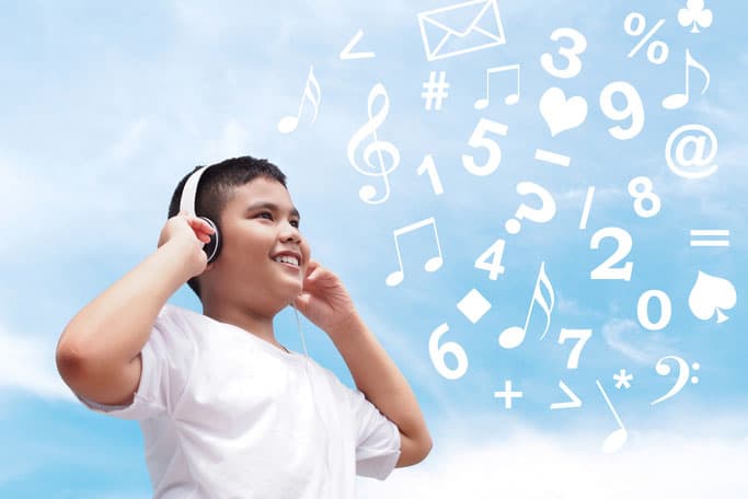Happy Asian boy with white shirt wearing headphone over blue sky background with number and music note. Online learning concept.